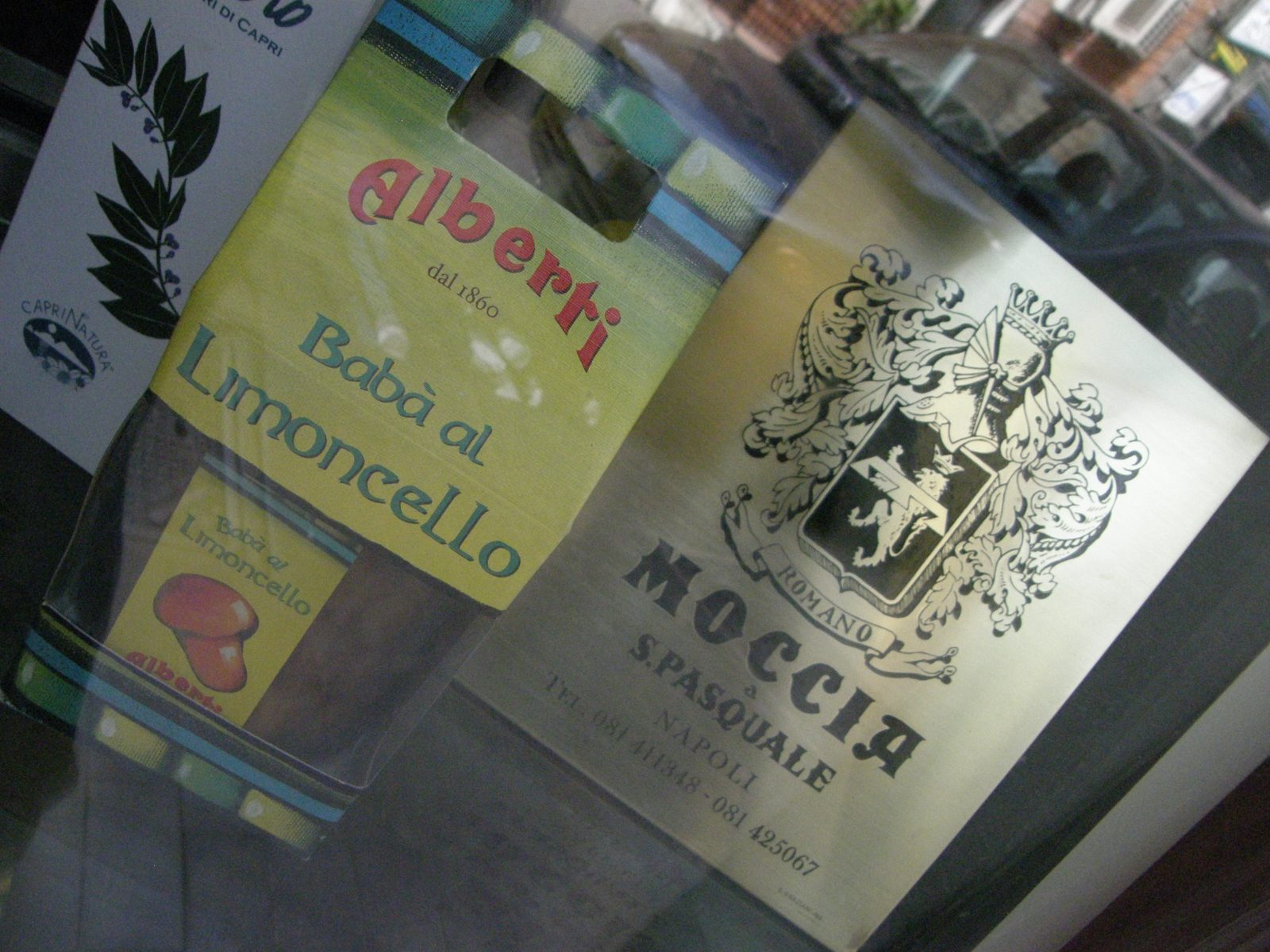 黄色と緑の箱に「Babà al Limoncello」の文字。隣に店の名前の入った紙