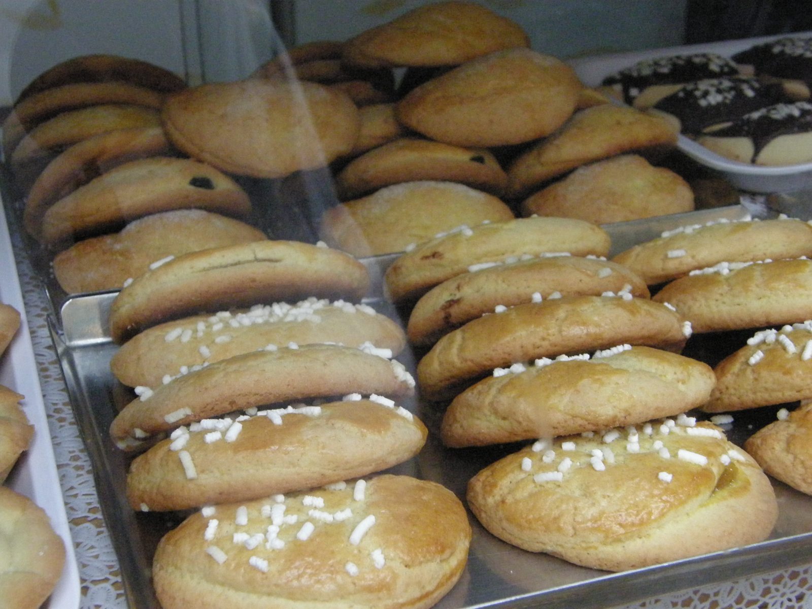 金属のトレイに、粒の砂糖を散らした半月形の焼き菓子がたくさん並ぶ